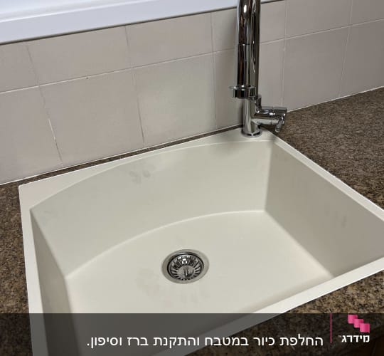 כיור מטבח עם ברז על משטח שיש חום